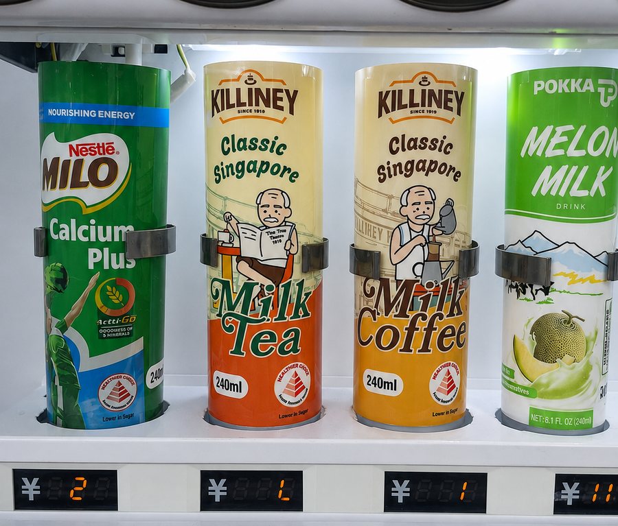 Close-up of chilled canned and bottled drinks inside a CVM vending machine in Singapore